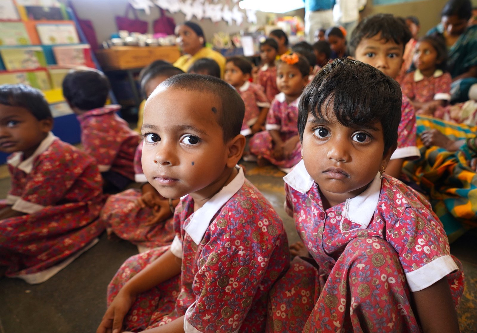 Young children in school uniforms attending early childhood education classes